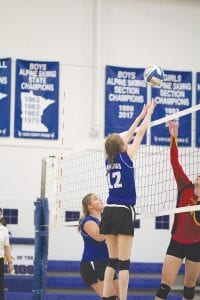 Above: With Jasmine Smith looking on, Linnea Gesch goes up high to block the ball against the Mountain Iron-Buhl Rangers. Right: Crouched like cats waiting to pounce, Abby Prom and Reilly Wahlers (in back of Prom) wait to see if Alyssa Lashinski makes—or misses—the kill on the ball. No worries. Lashinski got all of the ball and the point for the Vikings.