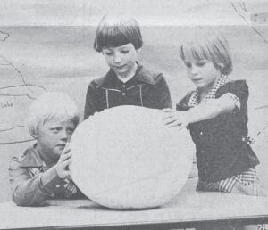 What weighs about 13 pounds, is nearly 11 inches high, is 17¼ inches in diameter, and 51½ inches in circumference? It’s this giant puffball found by Eric Humphrey near his parents’ Grand Marais home on Sept. 4, 1977. Eric brought the unusual find to school so all his friends could see it. From left are second-graders Tim Quaife, Eric Humphrey and Diane Hill inspecting the giant mushroom.