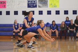 Top: Raina Ryden goes low to bump the ball while Alyssa Lashinski gets set to back her up. Above: Defying gravity, Meredith Sutton gets set to make a kill. Right: Abby Prom (3) had 20 set assists against the Rebels.