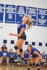 With Abby Prom looking on, Meredith Sutton jumps high into the air and gets ready to serve up a smoking hot volleyball to the other side of the court. Sutton went over 1,000 kills for her career against the Proctor Rails.