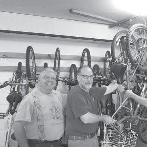 WOW volunteers Dan Strayer (L) and Jeff Kern with WOW bikes in church storage area.