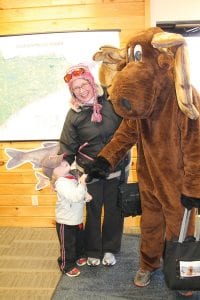 Murray the Moose shakes hooves with a little tot at the Moose Madness Family Festival. Although Murray is big—as are all moose—he doesn’t possess a mean bone in his brown furry body!