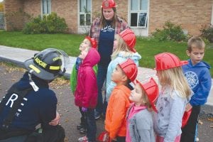 Seven volunteer firefighters from the Tofte and Schroeder fire departments took some time out of their busy schedules last week to bring three fire trucks and a Search and Rescue vehicle to the Birch Grove Community School to demonstrate what they do when a fire occurs or an accident happens and someone needs to be rescued. You can’t see it here, but the children are looking at a long tall ladder extended from one of the fire trucks. See more pictures on page A3.