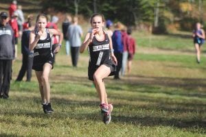 Lizzy Dover (left) and Anna Hay sprint to the finish in the middle school race at the conference meet. Hay nipped Dover by two seconds in the race that was 2,600 meters (about one and one-half miles) finishing with a time of 13:31.