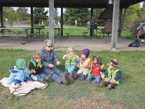 Outdoor play is a major theme at Cooperation Station Daycare. Even if it’s a bit nippy outside, the kids are bundled up and taken outside. Above, Karen Kobe, a master naturalist who volunteers, is leading the children through a fun activity. If the world seems to be going a bit crooked lately, these children are trying to steer it back in the right direction through imaginative play.