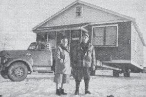 How bad was the January 1960 storm that battered Grand Marais? At left, Frank Lehto stands before his ice-encrusted house that sustained damage to the lake-side siding when a concrete wall, about 20 feet from the house, was crumbled, allowing the waves to dash against the building. Not to worry—the house was moved to a safer location by Backlund & Sons a week after the destructive storm struck. The house was taken across the street to the east side of the main harbor, where (it is hoped) the waves would not become quite so violent. The ferocious northeaster also crushed a concrete retaining wall in the harbor and dumped 250 cords of pulpwood into the lake.