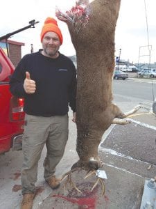 Left: Kevin Olson has good reason to give the “thumb’s up” sign. His 275-pound field dressed deer leads the big buck competition at Buck’s Hardware Hank by a large margin.