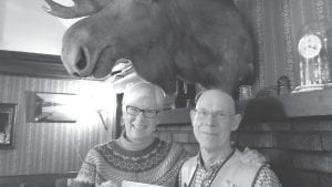 Under the watchful eye of the Birch Terrace resident moose, Lioness Ann Mershon and Lion Bob Spry hold a check for $6,000 that the two local clubs donated to help local teachers purchase classroom materials.