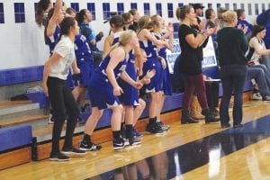 The players on the bench cheer wildly as the horn sounds, which assured the Vikings of an overtime win over their nearest rivals, the Silver Bay Mariners.