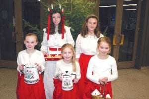 Cecelia Chmelik (wearing the crown) and Amy Carpenter, standing next to her, were both picked as St. Lucia this year for Julefest at Bethlehem Lutheran Church. St. Lucia court attendants from L-R: Ella Hallberg, Katie Shannon and Piper Sporn.