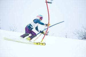 Above: Will Surbaugh (106) powered to a first-place win againsta strong boys’ field at Giants Ridge. Left: Snapping the gate asshe corners down the slalom ski racecourse is Reilly Wahlers.