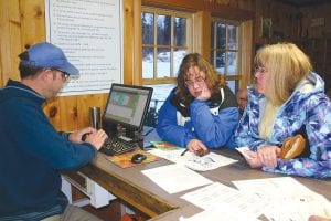 Denise Deithert (left) and Jennifer Serpico discuss camping sites with Grand Marais Recreation Park Director Dave Tersteeg, seated behind the computer. The two ladies drove from Hudson, Wisconsin to Grand Marais the night before to make sure they were in line when the tourist park office opened at 8 a.m. on January 2, the first day reservations could be made for the weekend of the Fisherman’s Picnic.