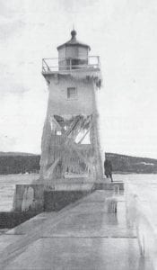 A 1937 winter storm left the lighthouse in the Grand Marais harbor covered in ice, a spectacle which the News-Herald described as “one big ice candle.” Since that time, careful observers will notice that the breakwater leading out to the light has been reconfigured.