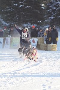 Rita Wehseler of Tofte waves to the crowd as she and her happy dog team tear off from the starting line of the Gunflint Mail Run 65-mile race. Wehseler finished in sixth place, about 45 minutes behind the first-place winning time (5:14:27) of Joanna Oberg of Ignace, Ontario.