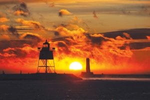 Brutal cold, dark clouds, mist steaming from the lake, a golden sun, caught between the two lighthouses before slowly sinking out of sight, made for a spectacular New Year’s sunset picture. Thank you, Santina for sending us this picture to share.