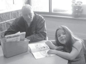 Above: Arvid Dahl reading with his granddaughter, Holly Dahl. Left: Doris Blank and Michelle Shute visiting at the Elder’s Christmas party.