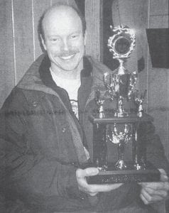 Colvill musher Mark Dunlap shows the third-place trophy he won at the Grand Casino Hinckley 1998 Great Trail Sled Dog Race in the six-dog pro-class during the last weekend of January 1998. Other local mushers competing in the race were Carrie Laboda, Neil Rasmussen, Charlie Laboda, Dean Gulden, Jason Fries and Alex Somers.