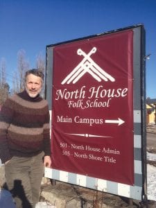 North House Folk School Executive Director Greg Wright poses next to the sign advertising the ever-growing folk school, which is looking for more space to expand into.