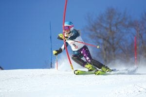 Above: Reilly Wahlers carves the snow with her skis as she snaps the gate on her way down the hill. Left: Sela Backstrom, wearing bib No. 46, flies down the salmon course at Giants Ridge