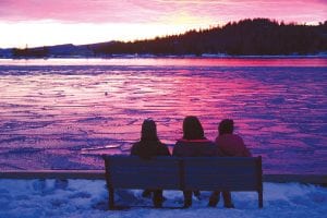 Although it was a bit chilly on the evening this photo was snapped, these three young ladies took the time to sit and view the sunset over the Grand Marais harbor. The lake is still occasionally making ice at night, and when it fractures from the waves and wind the ice looks like translucent puzzle pieces on the harbor.