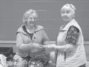 Stew cook off winner Missy Ullman receiving her winnings from her mother Carol Hackett, Elder Advisory Board vice chair.