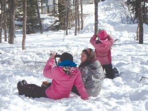 Every year kids in the fifth grade travel to Wolf Ridge Environmental Learning Center in Finland, Minnesota to learn about nature and what nature can teach us, often through hands-on activities. Above: Three children attempt to locate birds. Left: A student bravely walks high in the air through the ropes course.