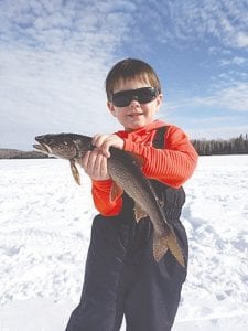 Bo knows fish! Looking like a movie star in his dark (are they Cartier Panthere?) sunglasses, Bo Christianson holds this big beautiful lake trout he pulled from the ice on a recent fishing trip he took with his dad and friends. While the days are warming up, below freezing nights are still keeping the ice intact and thick on most smaller area lakes, leaving the lakes safe to fish for at least a while longer.