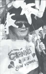 During the march Vicki Biggs- Anderson wore a black umbrella strung with cutout figures of the Parkland victims, names, age, when killed with AR-15.