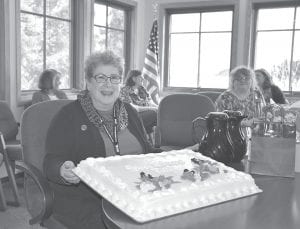 Lots to smile about! Patty poses for a quick picture before a larger crowd gathered to cut that cake and wish Patty well on her last day of work April 13. (Pictured behind Patty L-R are Agatha Armstrong, Carrie Newman, Valita Bockovich, and Janet Hari.)