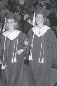 Salutatorian Linnea Henrikson (L) and Valedictorian Maya McHugh walk together after receiving their diplomas.