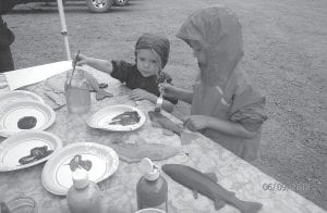 Above: When they weren’t fishing, kids were busy painting paper fish. Left: Young fisherman Salomon Ramey has a firm grip on his very slippery rainbow trout. Ramey’s fish was the biggest one caught all day on Mink Lake, which gave Salomon bragging rights for the day.