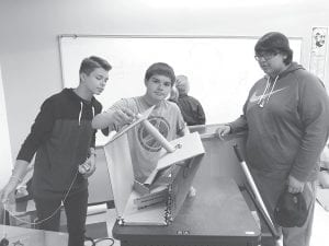 Pictured with their Rube Goldberg machine are: Tanner DeBoer, Caide Northrup, and Lyndon Magiskan as they play the role of engineers in trying to get a Rube Goldberg project to work.